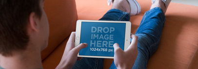 White iPad Mini Mockup Featuring a Young Teen Playing on his Living Room Couch a13058w