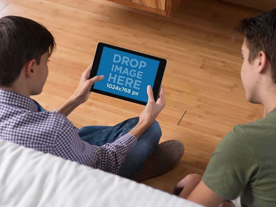 Pair of Teenagers at Home Playing on Their iPad Mini Mockup in Landscape Position