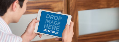 Teen Using his iPad Mini in Landscape Position Mockup to Play a Game in his Room a13057wide