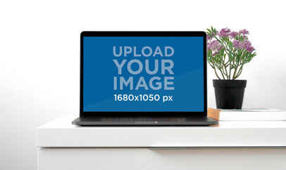 Mockup of a MacBook on a Desk with a Flower Pot