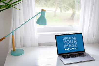 Mockup Featuring a MacBook Pro Placed on a Neat Desk by a Window 