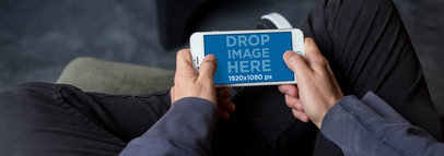 Teenager Sitting at Home and Playing on his White iPhone 7 Plus in Landscape Position Mockup