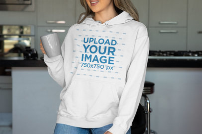 Mockup of a Smiling Woman in a Kitchen Wearing a Pullover Hoodie
