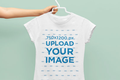 Mockup of a Hand Holding a Tee on a Hanger