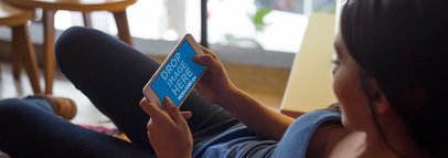 Young Woman Lying on a Couch and Playing on her White iPhone 7 Plus in Landscape Position Mockup
