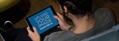 iPad Mockup in Landscape Position of a Man Sitting on a Couch