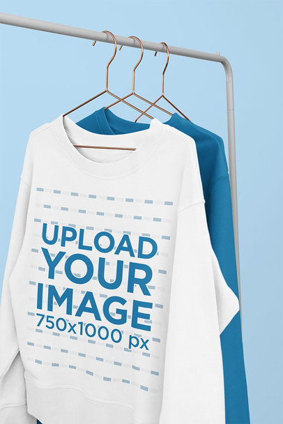 Mockup of Some Sweatshirts Hanging from a Metal Clothing Rack