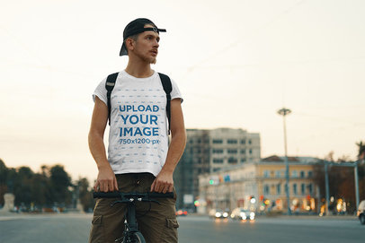 T-Shirt Mockup Featuring a Man Riding a Bike in an Urban Scenery