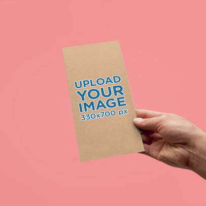 Mockup Featuring a Hand Holding a Vertical Bifold Brochure Against a Plain Background 