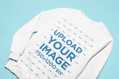 Mockup of a Customizable Crewneck Sweatshirt Lying Flat on a Colored Surface 
