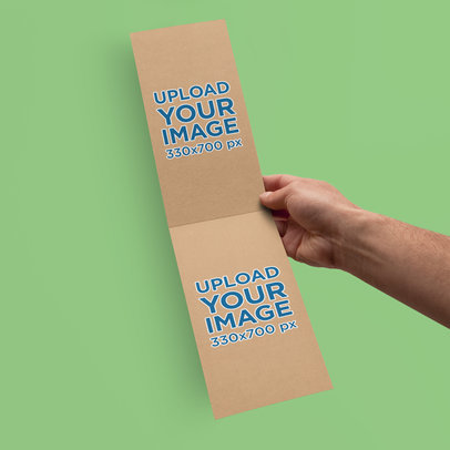 Mockup of a Man Holding a Vertical Brochure 4188-el1