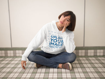 Pullover Hoodie Mockup of a Trendy Woman Sitting Cross-Legged in a Room