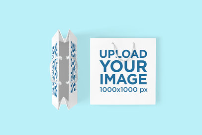 Mockup Featuring Two Customizable Gift Bags Placed on a Colored Surface 