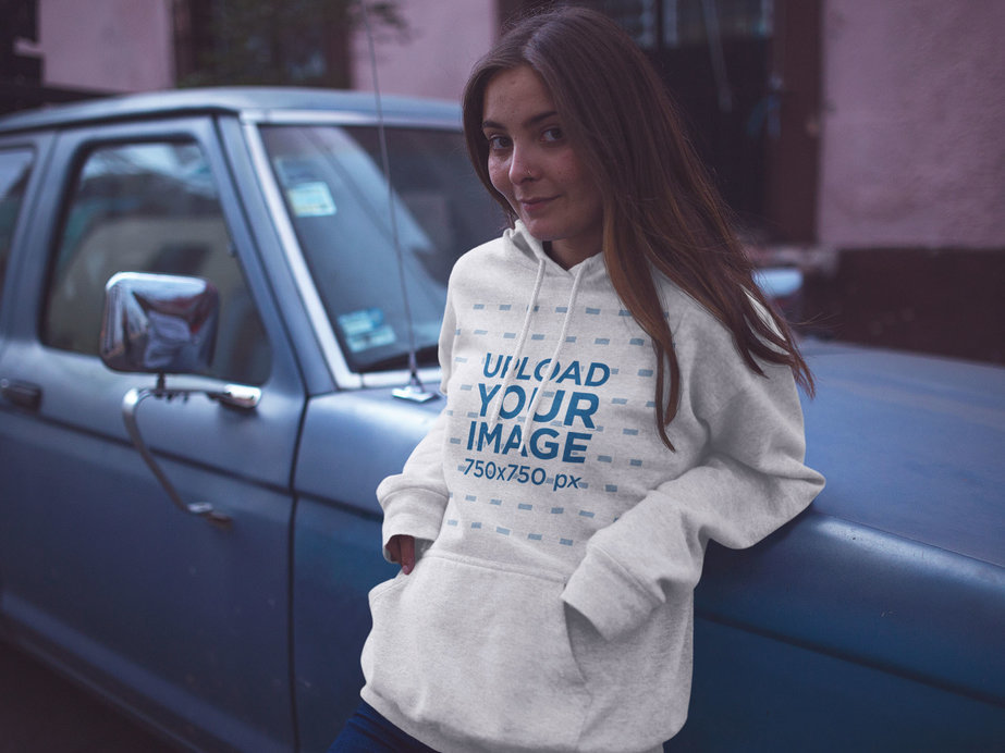 Pullover Hoodie Mockup of a Pretty Young Woman Leaning on a Car at Dusk