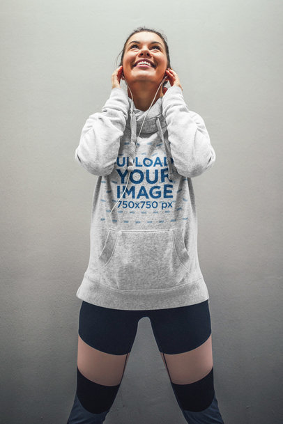 Mockup of a Woman with a Heathered Hoodie Happily Listening to Music