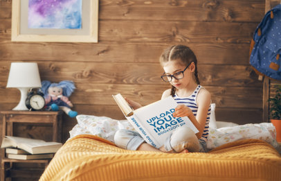 Mockup of a Little Girl Reading a Book in Bed