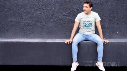 T-Shirt Video of a Playful Man Sitting in an Urban Scenario
