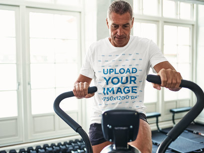 T-Shirt Mockup of a Man Working Out on a Stationary Bike