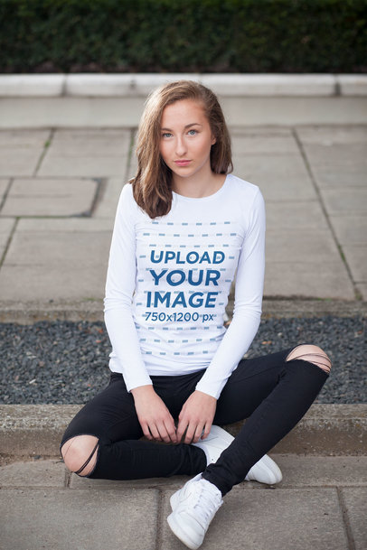 Long Sleeve Tee Mockup of a Young Woman Sitting on a Sidewalk 