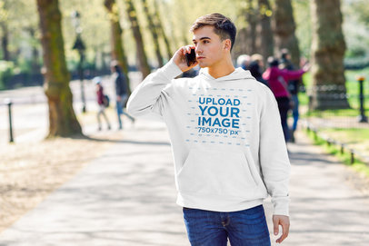 Pullover Hoodie Mockup of a Man Talking on the Phone at a Park