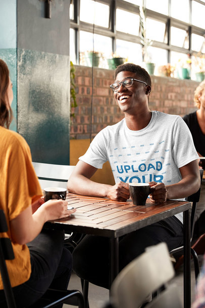 T-Shirt Mockup of a Happy Young Man Talking to a Friend at a Restaurant 