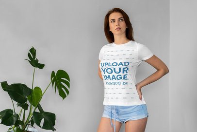 T-Shirt Mockup Featuring a Woman Posing Next to an Indoor Plant 