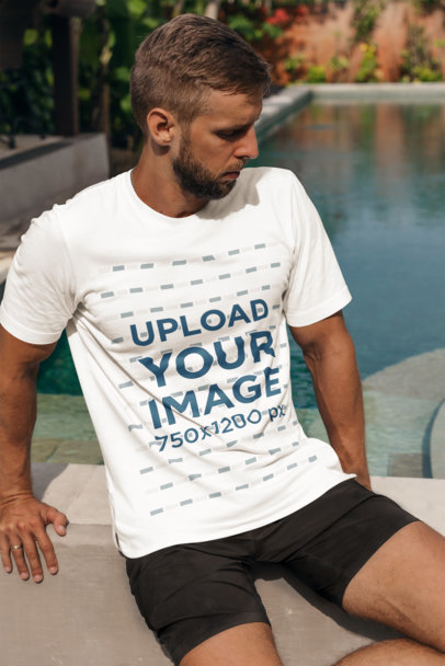 Mockup of a Bearded Man with a T-Shirt Sitting by a Pool