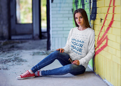 Crewneck Sweatshirt Mockup of a Woman Sitting Against a Graffiti Wall 4353-el1