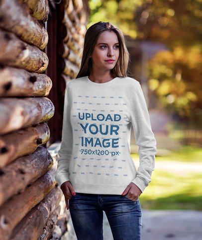 Mockup of a Woman Wearing a Heathered Crewneck Sweatshirt by a Cabin 