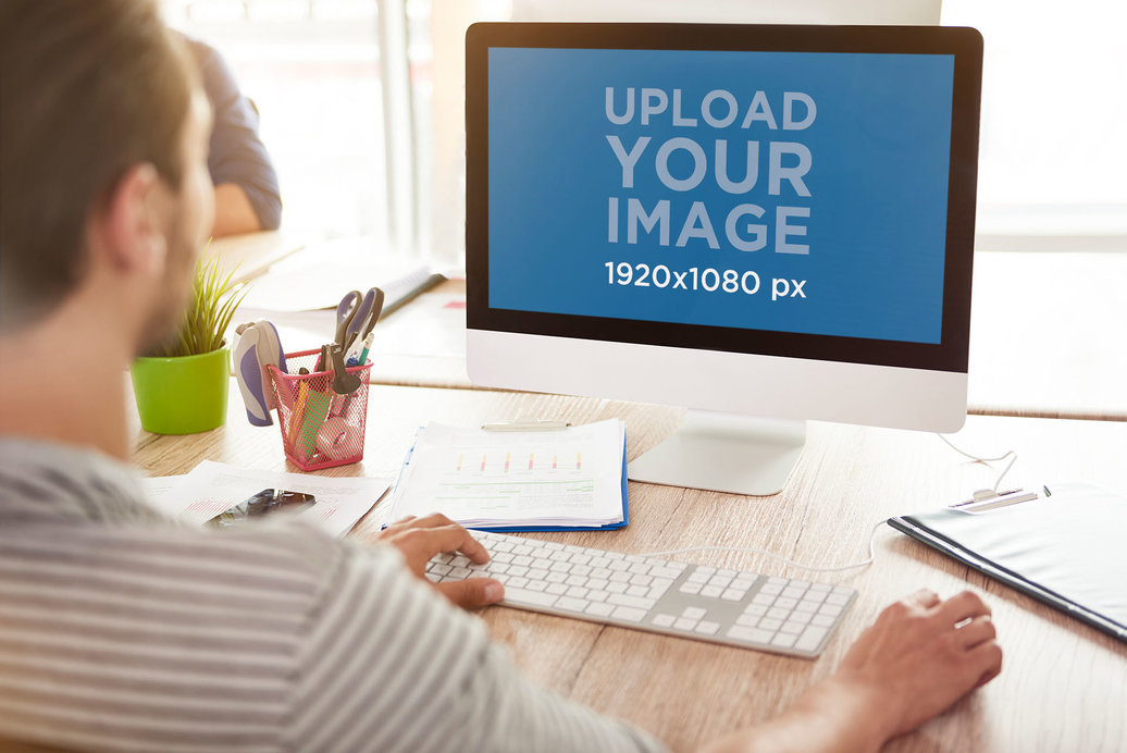 Placeit - Over-the-Shoulder View Mockup of a Man Using an iMac