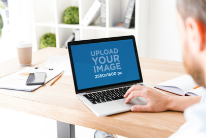 MacBook Mockup of a Man Working on His Desk