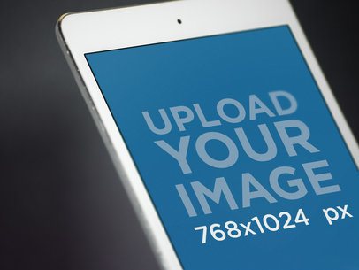White iPad Mini Closeup Mockup in Angled Portrait Position Over a Dark Background a12758