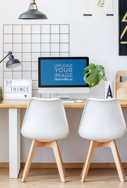 Mockup of an iMac Placed in Front of Two Minimalist Chairs