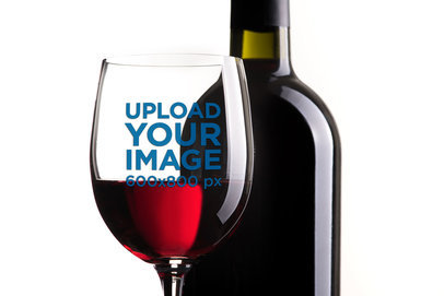 Mockup of a Wine Glass in Front of a Bottle