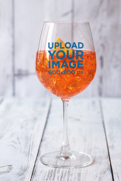 Mockup of a Wine Glass Filled with a Cold Orange-Infused Drink