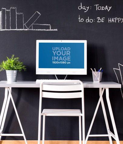 Mockup of a Desktop Computer Placed on a Desk Against a Chalkboard Wall