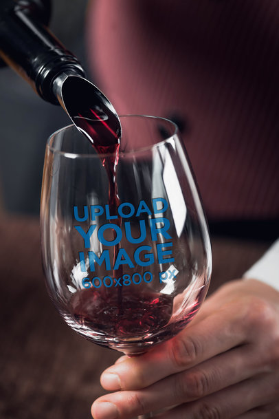 Mockup of a Man Pouring Wine in a Stemless Wine Glass