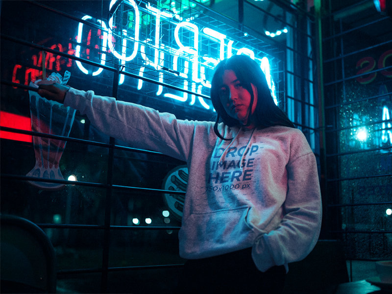 Mockup of an Asian Woman Wearing a Pullover Hoodie Near Neon Lights