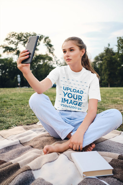 Mockup of a Teenager with a T-Shirt Taking a Selfie at the Park 