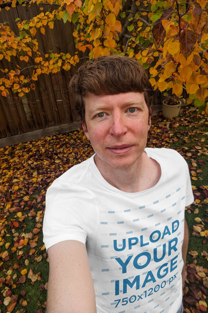 Mockup of a Man with a Shirt Taking a Selfie on an Autumn Day 
