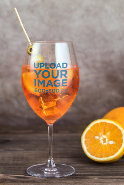 Mockup of a Wine Glass with an Olives Stick and an Orange Drink 36621-r-el2