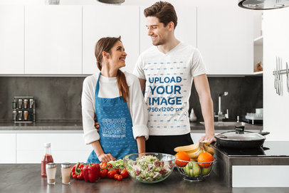 Apron and T-Shirt Mockup Featuring a Couple Making Dinner 