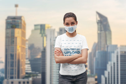 Face Mask Mockup of a Woman Wearing a T-Shirt and Posing With Her Arms Crossed