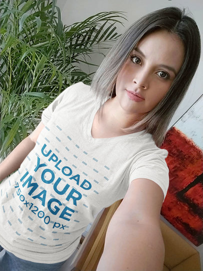 Mockup of a Woman with a Heathered V-Neck Tee Taking a Selfie at Home