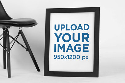 Mockup Featuring an Art Print Placed on the Floor Next to a Modern Chair 