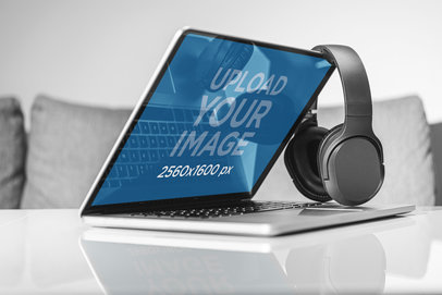 Mockup of a MacBook Pro Semi-Opened Next a Set of Headphones 37300-r-el2