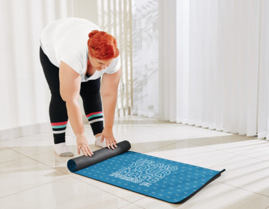 Mockup of a Woman Rolling Up Her Yoga Mat
