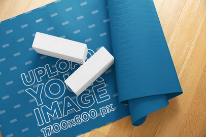 Mockup of a Half-Rolled Yoga Mat over a Wooden Surface
