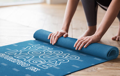 Mockup of a Woman Rolling Up Her Sublimated Yoga Mat