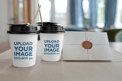 Mockup Featuring Two Customizable Coffee Cups and a Letter 
